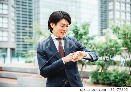 A businessman who is impatient looking at the clock (late) 83477295