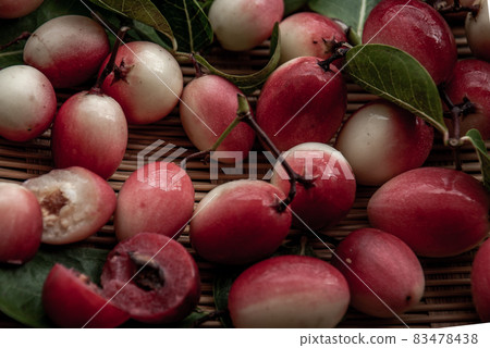 Bengal-Currants, Carandas-plum or Karonda fruit (Carissa carandas L.) sour taste fruit in Wooden cup on wicker. Bengal-Currants, Carandas-plum or Karonda fruit (Carissa carandas L.) sour taste fruit in Wooden cup on wicker. 83478438