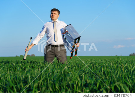 businessman poses with a spyglass in a green field, he looks an idea or something, business concept, green grass and blue sky as background businessman poses with a spyglass in a green field, he looks an idea or something, business concept, green grass and blue sky as background 83478764