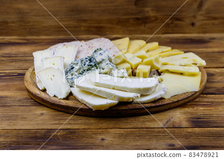 Cheese platter with different kinds of cheese on wooden table 83478921