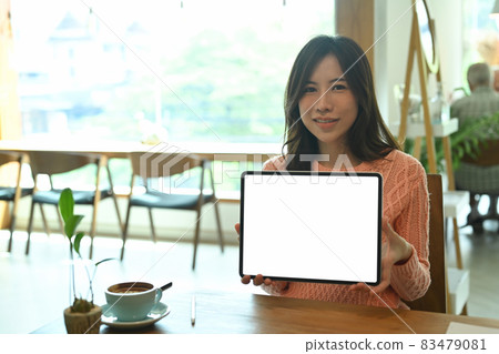 Smiling asian woman holding digital tablet with empty screen. Smiling asian woman holding digital tablet with empty screen. 83479081