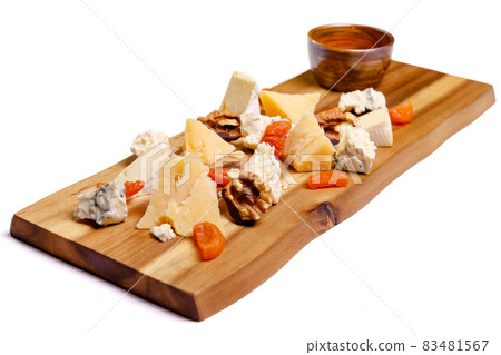 Close-up view of delicious cheese plate with nuts on wooden tabletop 83481567