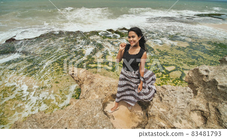 Indonesian girl posing on a beautiful and rocky beach in Bali. Idonezia. Indonesian girl posing on a beautiful and rocky beach in Bali. Idonezia. 83481793