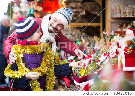 Little girl with dad buying decorations for Xmas Little girl with dad buying decorations for Xmas 83482010