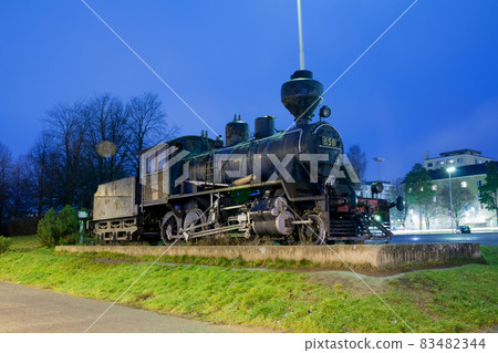 KOUVOLA, FINLAND - NOVEMBER 8, 2018: Old steam locomotive as an exhibit at the Kouvola railway station in Finland at night. KOUVOLA, FINLAND - NOVEMBER 8, 2018: Old steam locomotive as an exhibit at the Kouvola railway station in Finland at night. 83482344