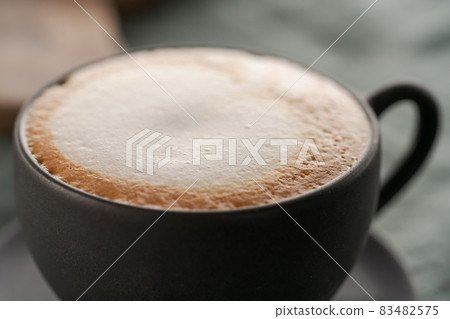 Cappuccino in black cup with ciabatta slices with chocolate spread on background Cappuccino in black cup with ciabatta slices with chocolate spread on background 83482575