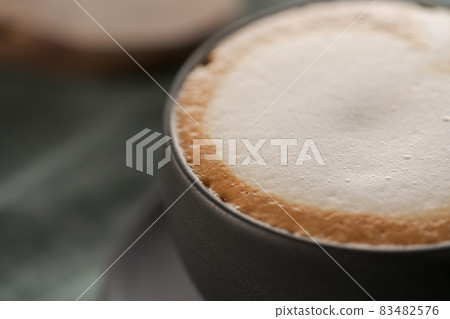 Cappuccino in black cup with ciabatta slices with chocolate spread on background Cappuccino in black cup with ciabatta slices with chocolate spread on background 83482576
