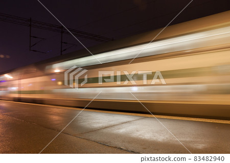 Train in motion on the station at night, long exposure photo. 83482940