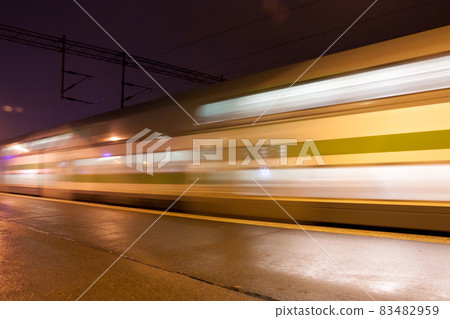 Train in motion on the station at night, long exposure photo. Train in motion on the station at night, long exposure photo. 83482959