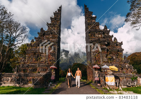 Beautiful couple at the Baltic temple. Man and woman traveling in Indonesia. Couple at the Bali gate. The couple travels the world. Travel to tourist places in Asia. Tourists in Bali. Copy space. 83483118