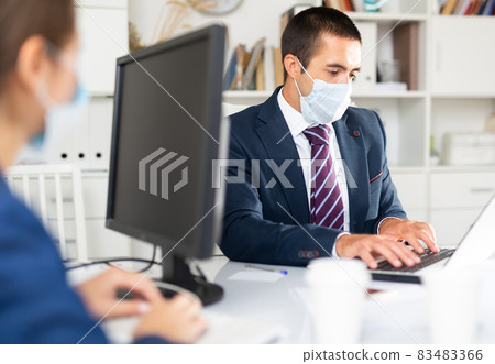 Director in protective medical mask gives instructions to secretary Director in protective medical mask gives instructions to secretary 83483366