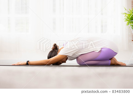 Asian woman working out in sportswear while doing yoga, seated in Child exercise, Balasana stance. 83483800