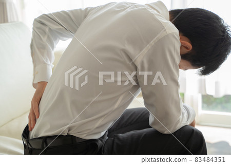 一個商人坐在沙發上傷了他的背 一個商人坐在沙發上傷了他的背 83484351