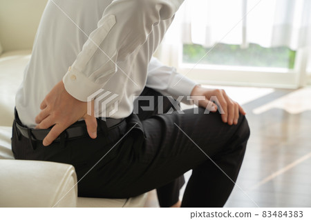 一個商人坐在沙發上傷了他的背 83484383