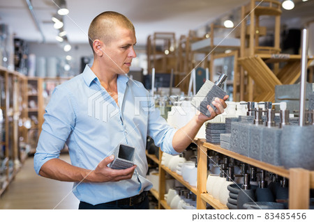 Portrait of man choosing deodorant in dishware store 83485456