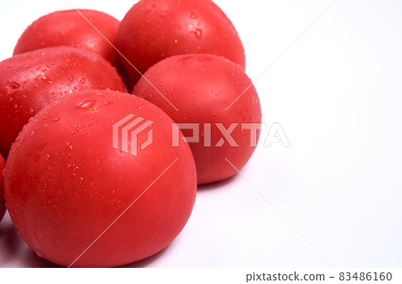 Red tomatoes on a white background. Free space for text. Water drops on wet vegetables. 83486160