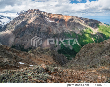 Dangerous mountain couloir. Colorful sunny landscape with cliff and big rocky mountains and epic deep gorge. High stone peaks of Altai mountains. 83486189