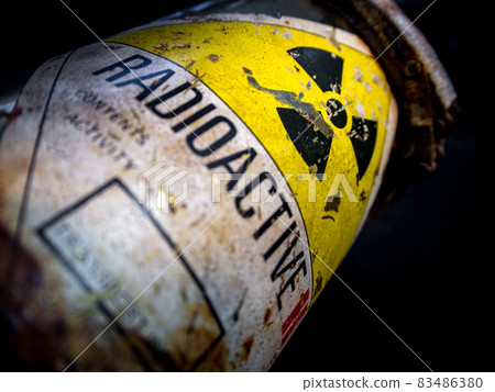 Radiation warning sign on the rusty and decay radioactive material container 83486380