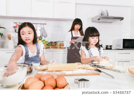 Attractive young woman and dauther cute daughter are cooking on kitchen 83488787
