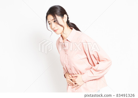 A woman holding her stomach by hand 83491326
