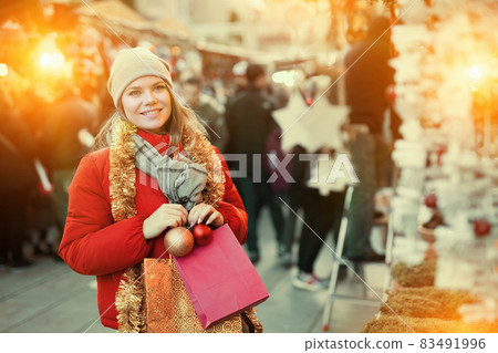 Girl choosing Christmas gifts outdoor on the street 83491996