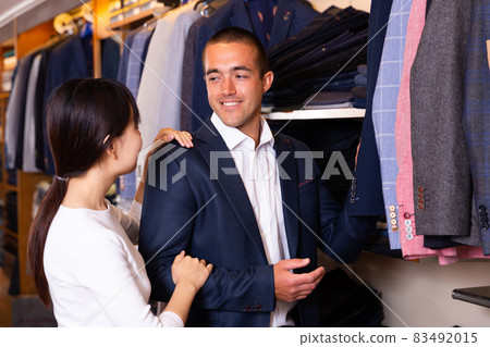 Couple looking for suit jacket in shop Couple looking for suit jacket in shop 83492015