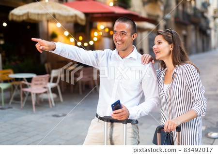 Tourist couple pointing at sights while walking around city Tourist couple pointing at sights while walking around city 83492017