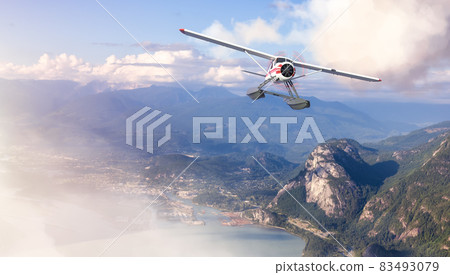 Seaplane Flying over the touristic town and Mountains Landscape. 83493079