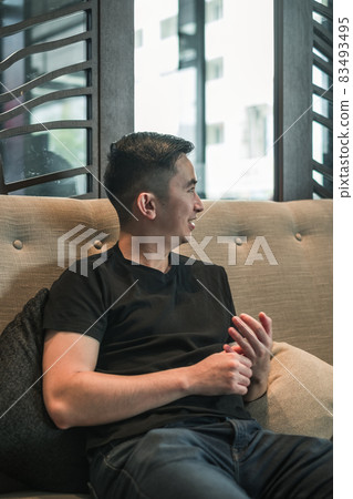 Asian young handsome man sitting in coffee shop, talking and smiling. chinese guy, millennials life, lifestyle in the big city, Modern Asia  83493495