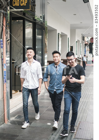 Portrait of Three asian young men in casual clothing walking on the street and smiling. Asia, Chinese people, real life concept, group of friends 83493502