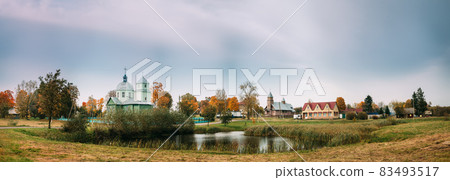 Porplishte, Dokshitsy District ,Vitsebsk Region, Belarus. Old Wooden Church of Transfiguration And Catholic Church Of Virgin Mary In Autumn Day. Panoramic View Panorama Porplishte, Dokshitsy District ,Vitsebsk Region, Belarus. Old Wooden Church of Transfiguration And Catholic Church Of Virgin Mary In Autumn Day. Panoramic View Panorama 83493517
