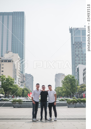 Three asian young men standing on the street and smiling. Asia, street in Vietnam, Locals, Chinese people, real life concept, sunny day, summer Three asian young men standing on the street and smiling. Asia, street in Vietnam, Locals, Chinese people, real life concept, sunny day, summer 83493518