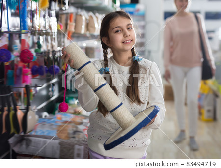Portrait of cute kid girl, choosing accessories for cat Portrait of cute kid girl, choosing accessories for cat 83494719
