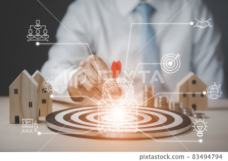 Targeting the business concept, Businessman touch red arrow dart to virtual target dart board,Executive marketing, investment goal and target for business investment concept, mini home and Coins stack 83494794
