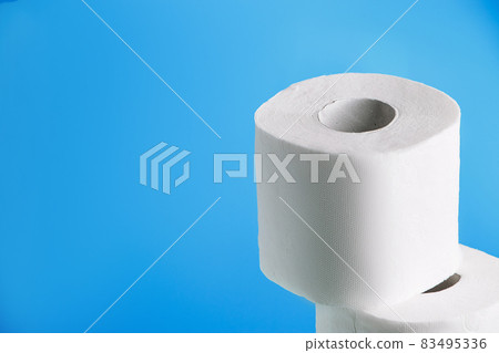 One roll of toilet paper on a blue background. Panic purchase of essential goods. The coronavirus epidemic in the world. Shortage of goods in the supermarket. 83495336