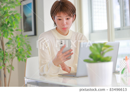 一位看著智能手機並關注新聞報導的女性 83496613