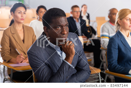 Focused man listening to lecture at conference Focused man listening to lecture at conference 83497144