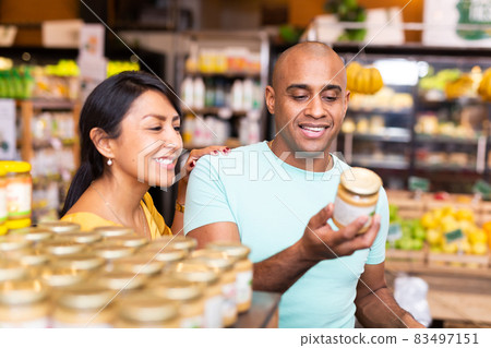 Married couple choosing canned food at grocery store Married couple choosing canned food at grocery store 83497151