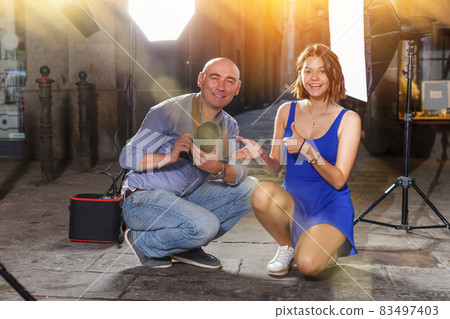 girl and professional photographer during photo shoot 83497403
