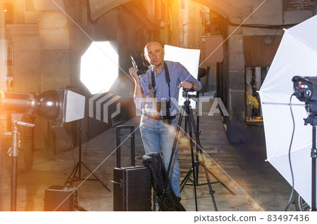 Portrait of positive photographer with his camera during photo s Portrait of positive photographer with his camera during photo s 83497436