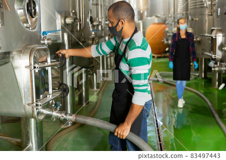 Male worker in mask working at winery Male worker in mask working at winery 83497443