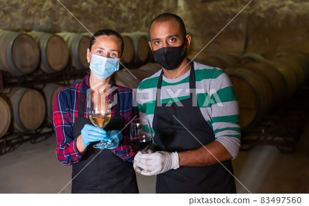 Two winemakers posing with wine in glasses Two winemakers posing with wine in glasses 83497560