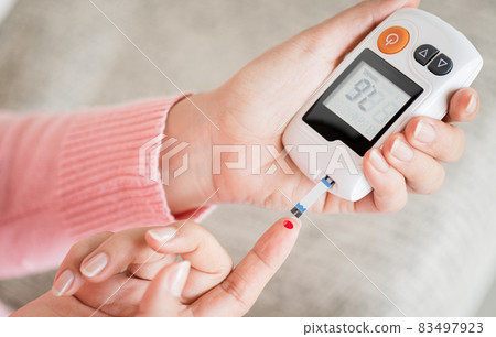 Close up woman hands checking blood sugar level by glucose meter for diabetes tester using as medicine, glycemia, healthcare and medical concept. Close up woman hands checking blood sugar level by glucose meter for diabetes tester using as medicine, glycemia, healthcare and medical concept. 83497923