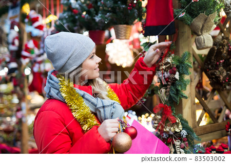 Young female near counter with xmas gifts on street market 83503002