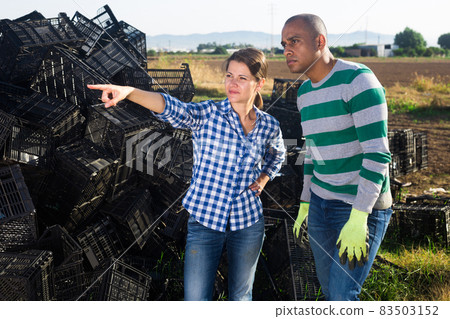 Farm owner gives instructions to the hired worker on the field 83503152
