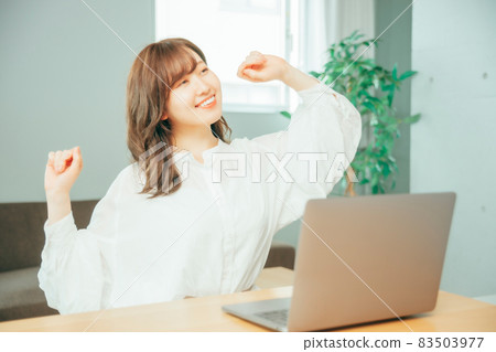 Woman stretching in front of a laptop 83503977