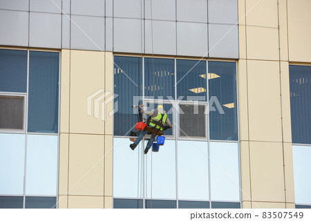 Man Cleaning windows on a Office Building Man Cleaning windows on a Office Building 83507549