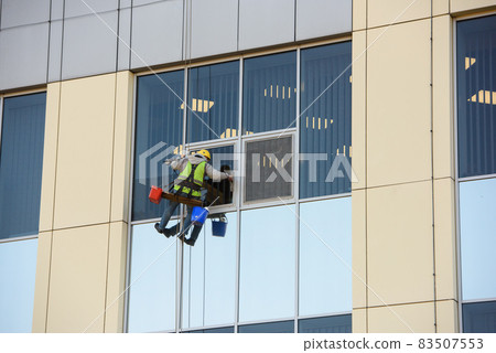Man Cleaning windows on a Office Building Man Cleaning windows on a Office Building 83507553