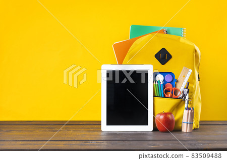 Backpack, textbooks, stationery and school supplies on wooden desk. 83509488