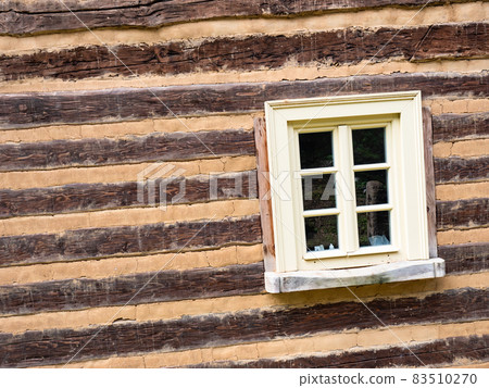 Window in wall from logs and joints erased with clay 83510270